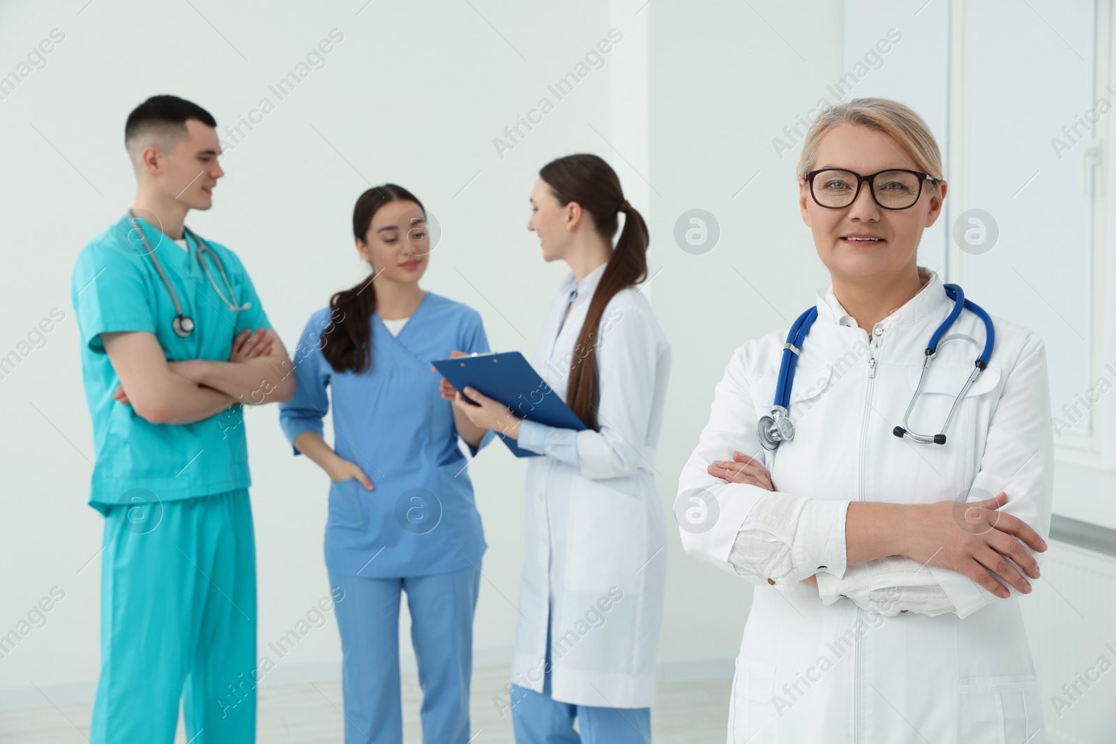 Photo of Portrait of doctor near colleagues in clinic