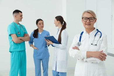 Photo of Portrait of doctor near colleagues in clinic