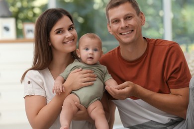 Photo of Portrait of happy family with their cute baby at home