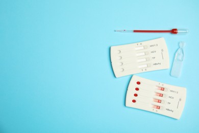 Photo of Disposable express hepatitis test kit on light blue background, flat lay. Space for text