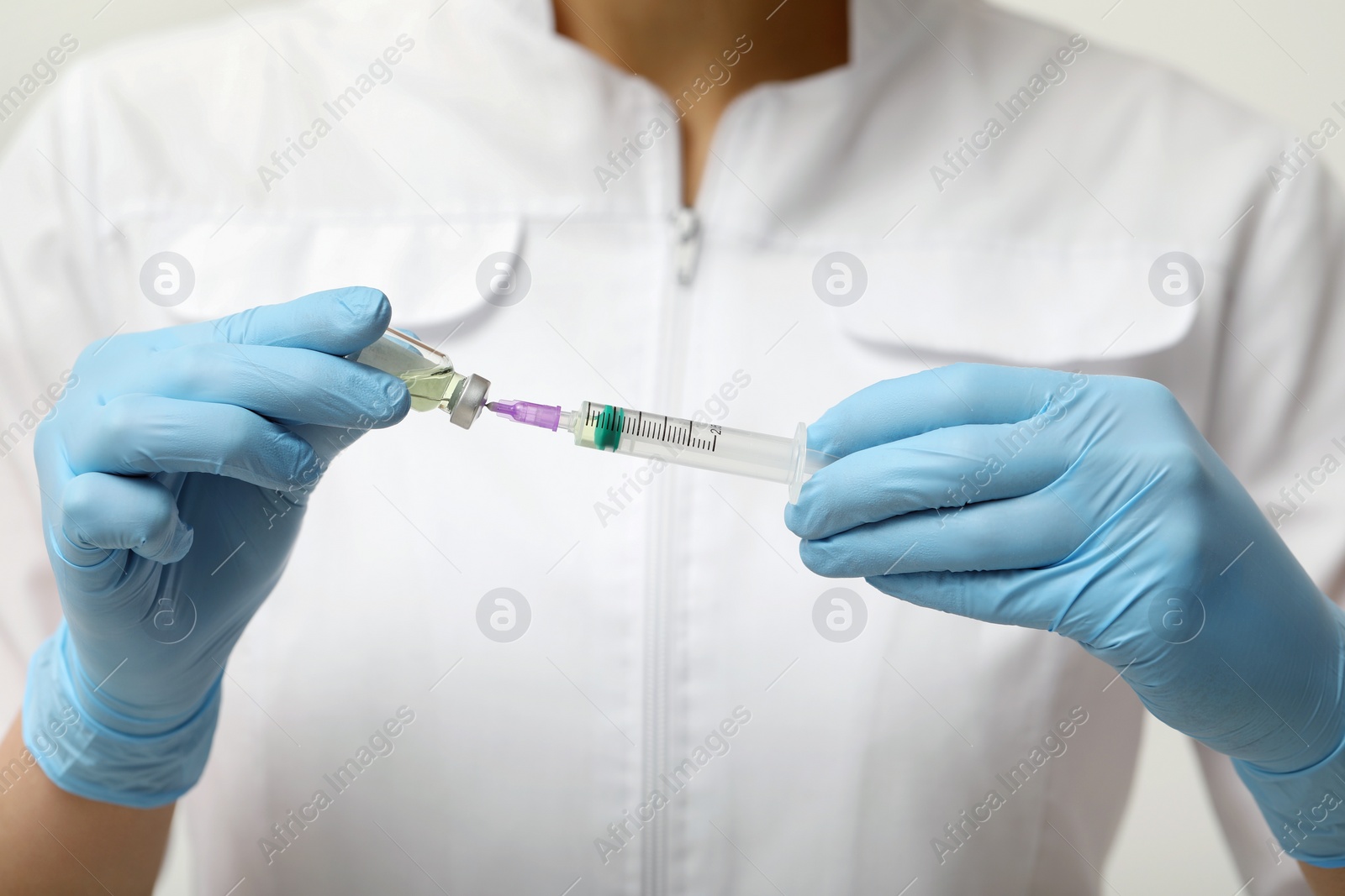 Photo of Doctor filling syringe with hepatitis vaccine from glass vial, closeup