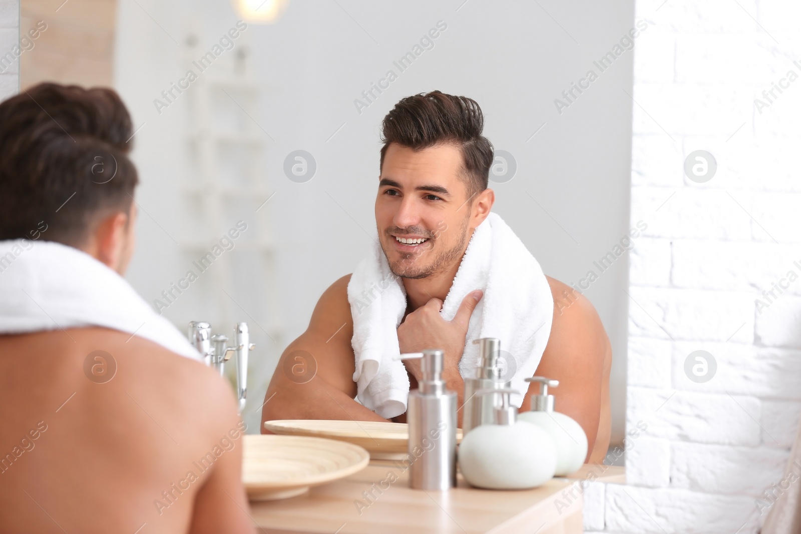 Photo of Young man with stubble ready for shaving near mirror in bathroom