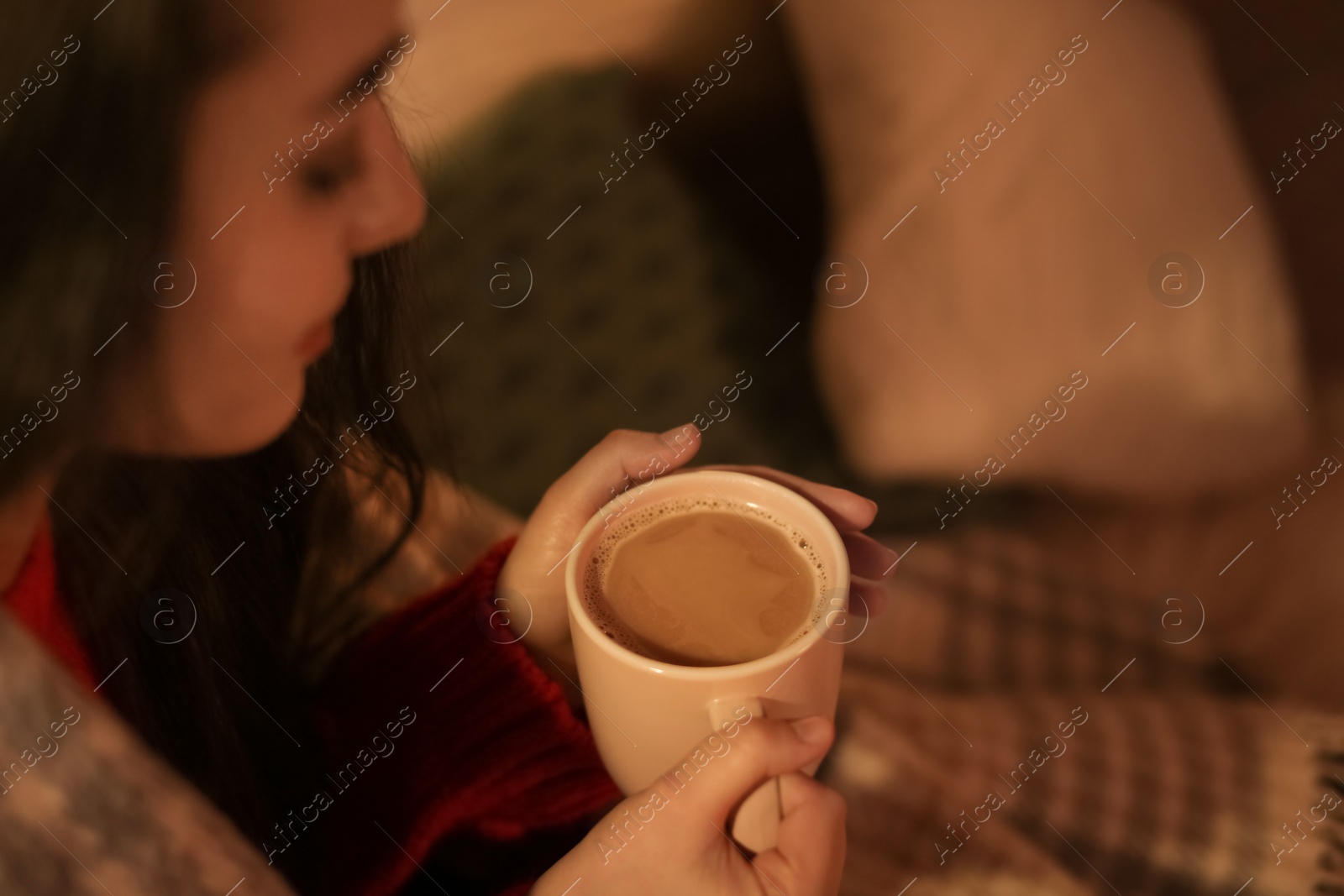 Photo of Young woman drinking coffee at home, closeup. Winter season