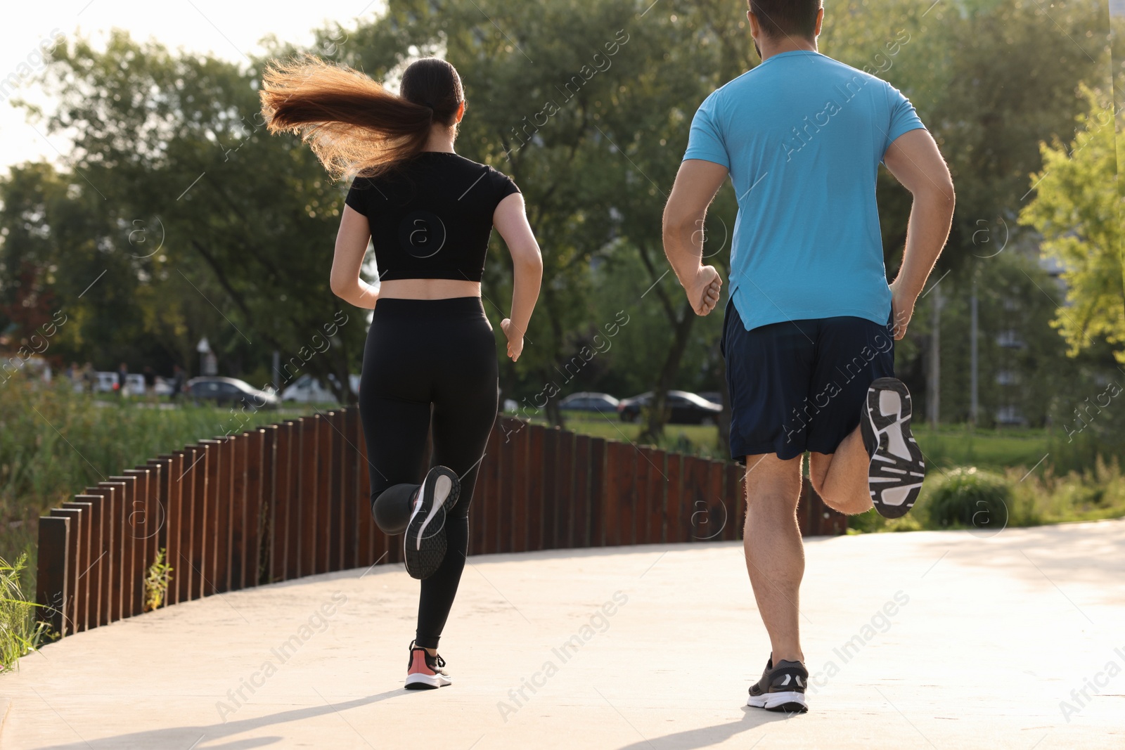 Photo of Healthy lifestyle. Couple running outdoors, back view