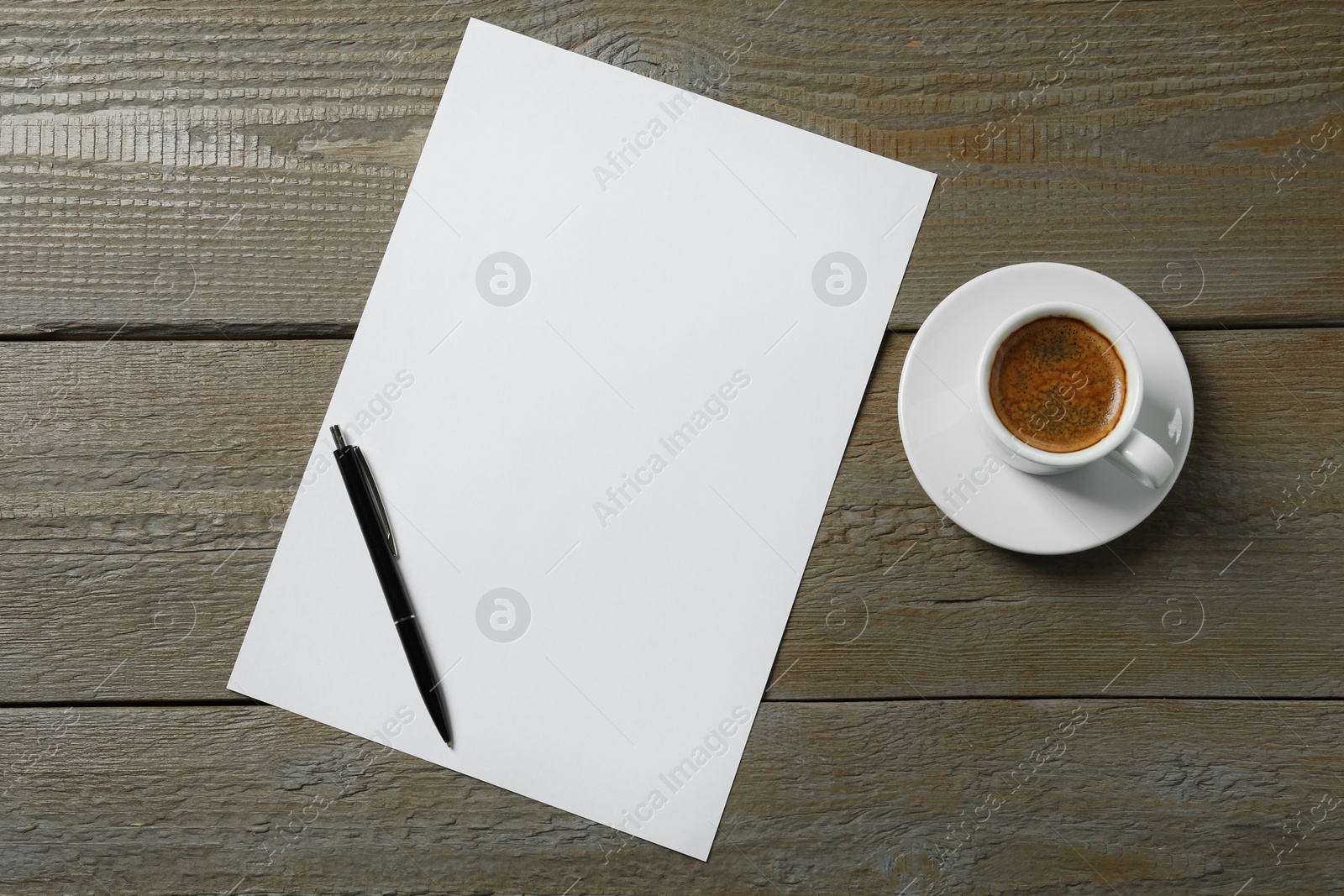 Photo of Blank paper sheet, pen and cup of coffee on wooden table, flat lay. Space for text