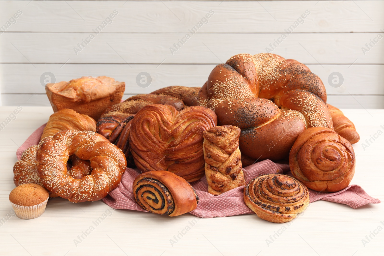 Photo of Different tasty freshly baked pastries on white table