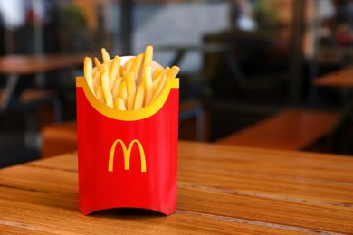 Photo of MYKOLAIV, UKRAINE - AUGUST 11, 2021: Big portion of McDonald's French fries on table in cafe. Space for text