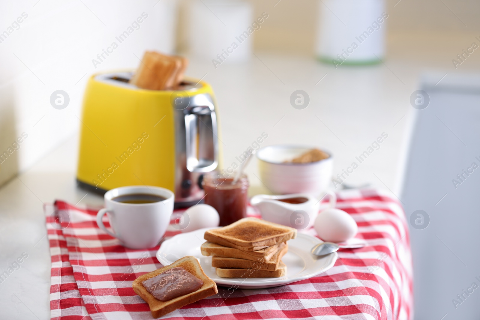 Photo of Modern toaster and delicious breakfast on table in kitchen