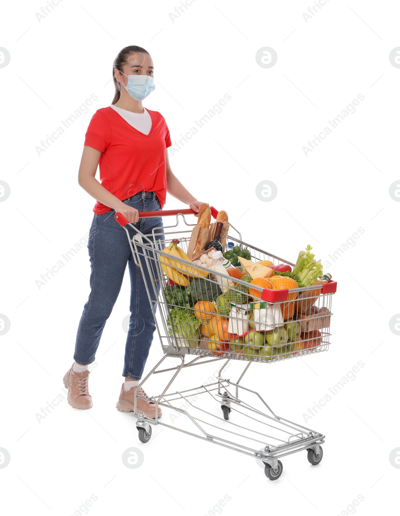 Photo of Woman with protective mask and shopping cart full of groceries on white background