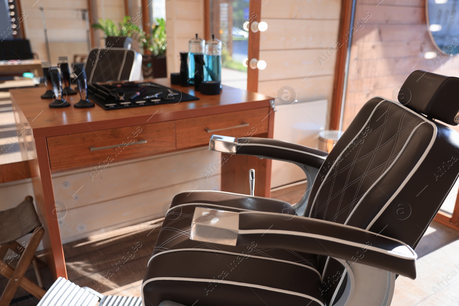 Photo of Stylish hairdresser's workplace with professional armchair in barbershop