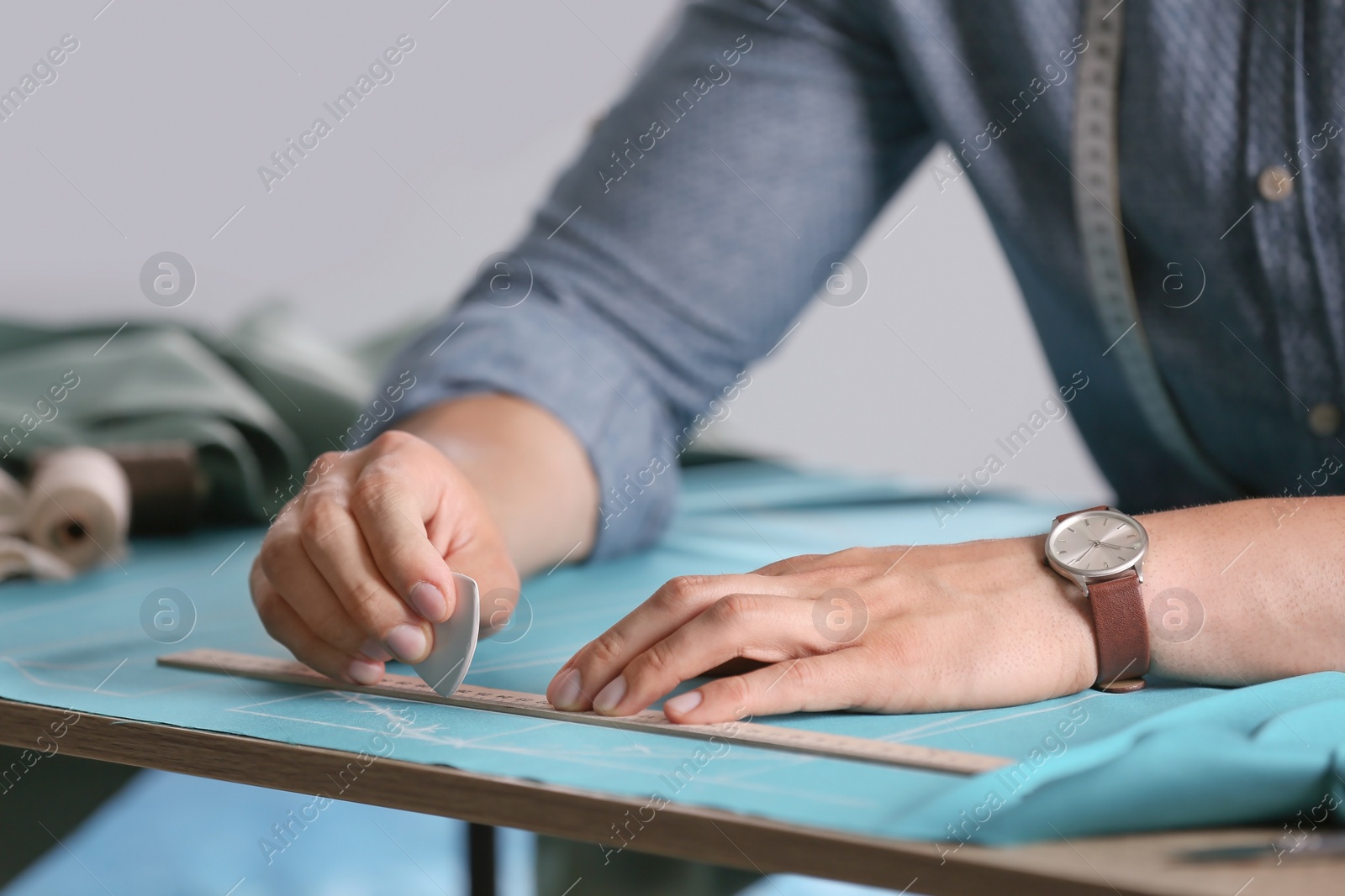 Photo of Tailor working at table in atelier, closeup