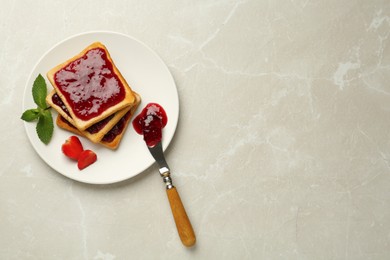 Toasts served with tasty jam, mint and strawberry on light marble table, top view. Space for text