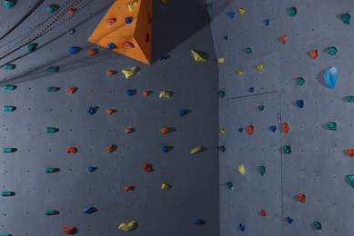 Photo of Climbing wall with holds in gym. Extreme sport