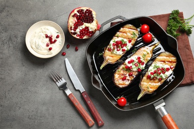 Flat lay composition with grill pan of fried eggplants on gray table