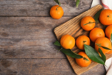 Photo of Flat lay composition with fresh ripe tangerines and space for text on wooden background