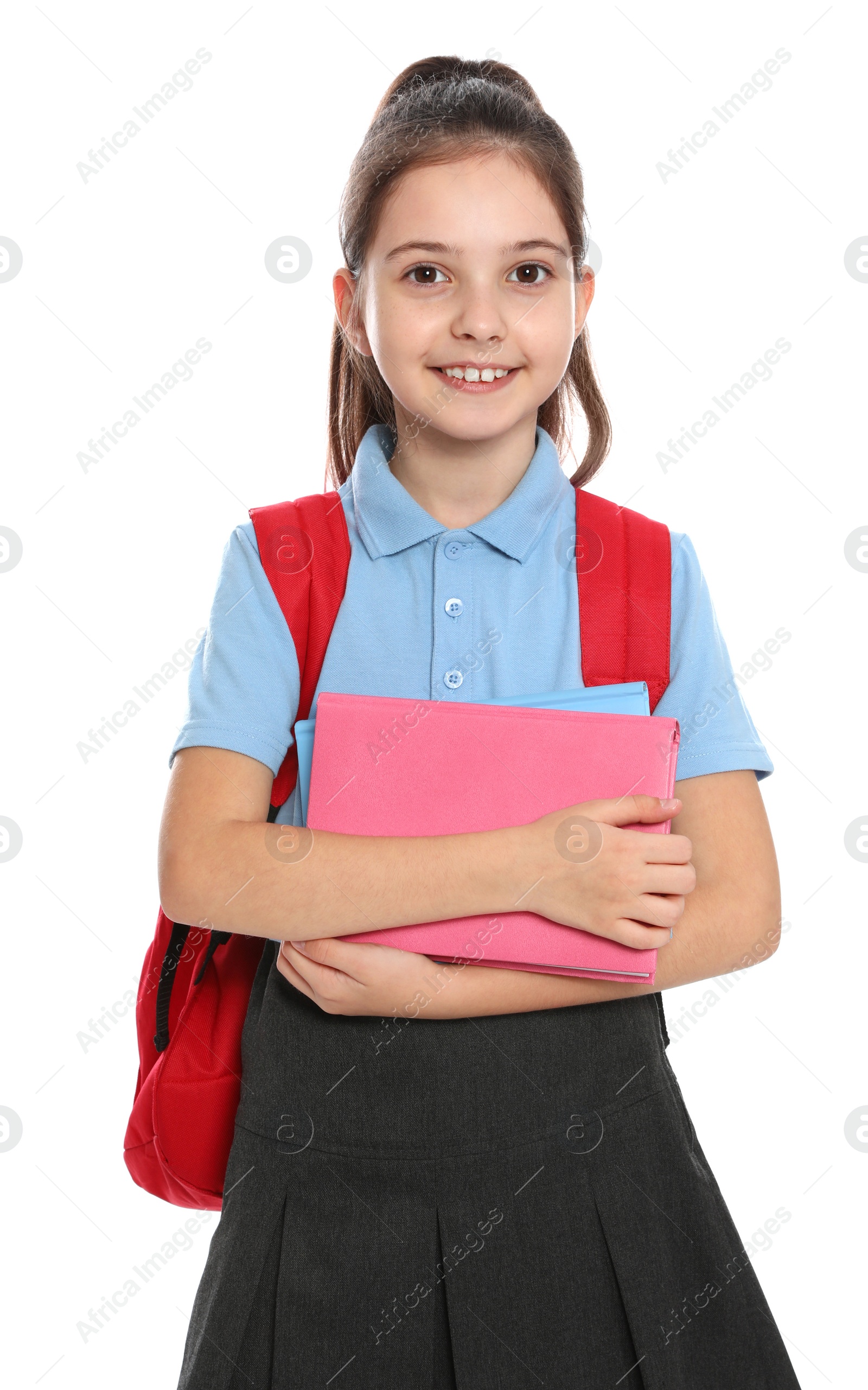 Photo of Cute little girl in school uniform with backpack and stationery on white background