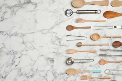 Photo of Set of cooking utensils on white marble table, flat lay. Space for text