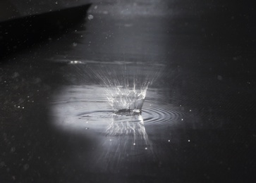 Photo of Splash of water on dark background. Rainy weather