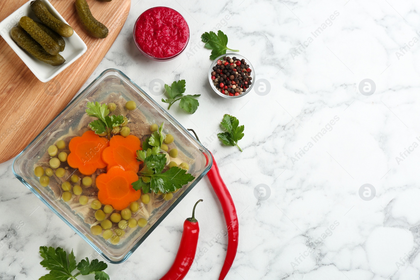 Photo of Delicious aspic with meat and vegetables served on white marble table, flat lay. Space for text