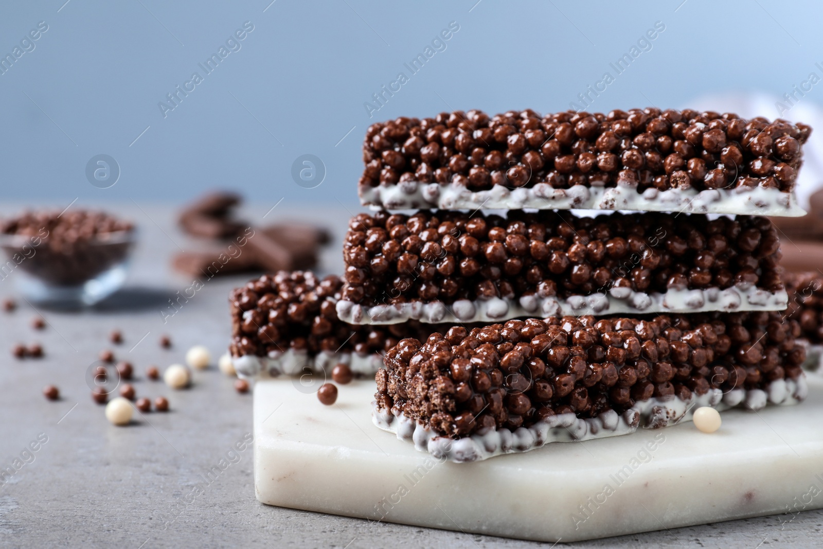 Photo of Delicious rice crispy treats on grey table, closeup