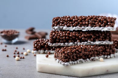 Photo of Delicious rice crispy treats on grey table, closeup