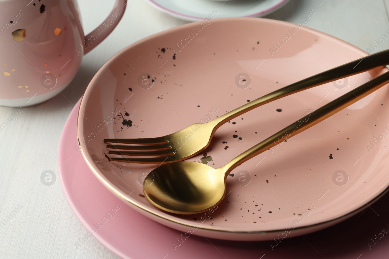 Photo of Stylish empty dishware and cutlery on white wooden table, closeup