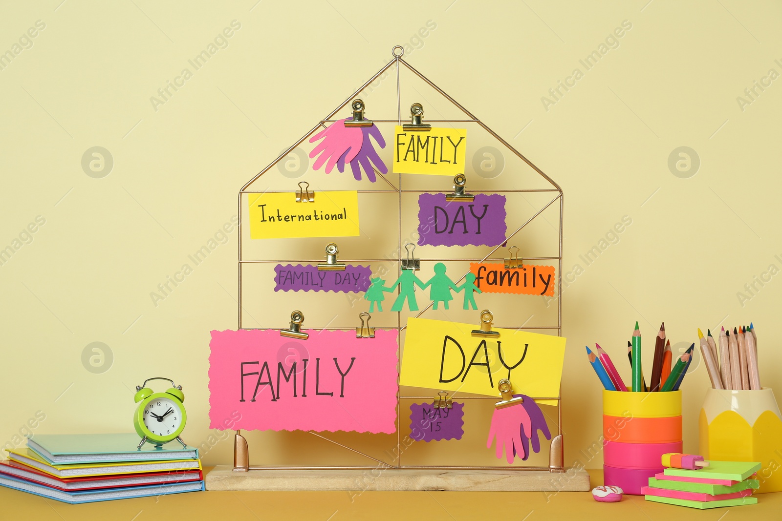 Photo of Happy International Family Day. Composition with stationery and cards on table against beige background