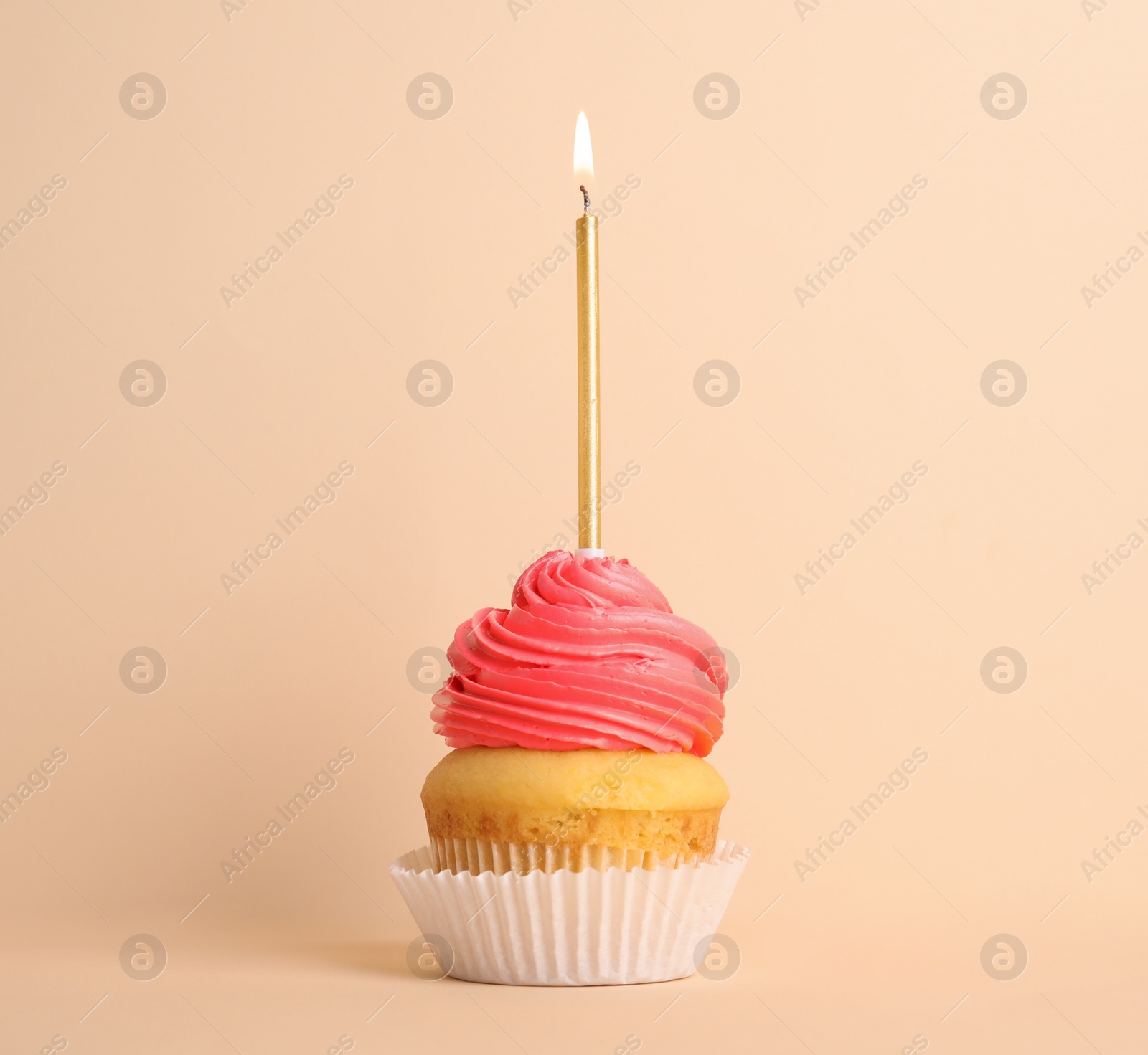 Photo of Birthday cupcake with candle on beige background