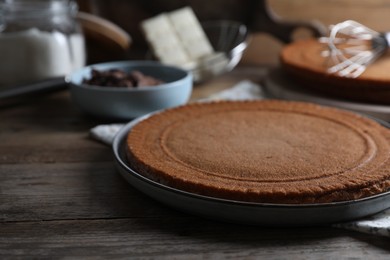 Delicious homemade sponge cake and ingredients on wooden table, closeup