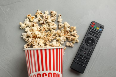 Photo of Modern tv remote control and popcorn on grey table, flat lay