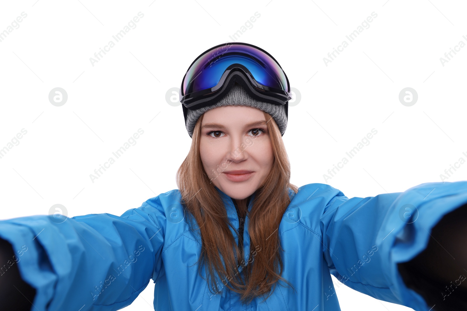 Photo of Beautiful woman in ski goggles taking selfie on white background