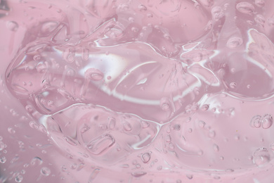 Photo of Pure transparent cosmetic gel on pink background, closeup