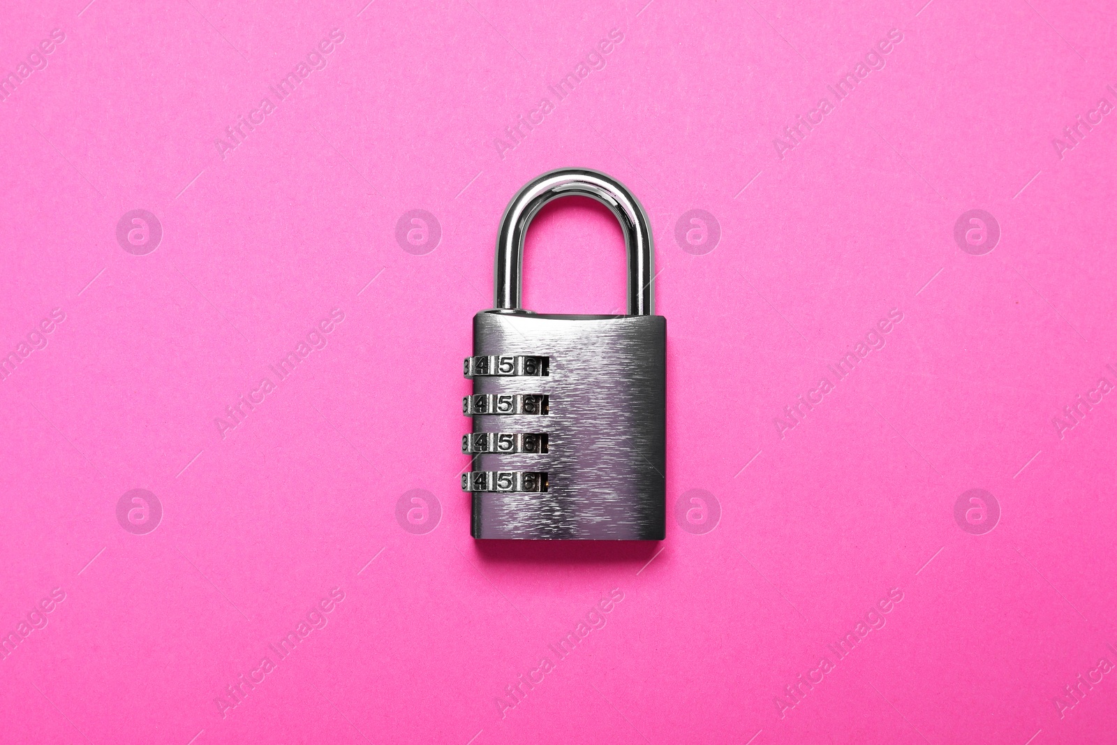 Photo of One steel combination padlock on pink background, top view