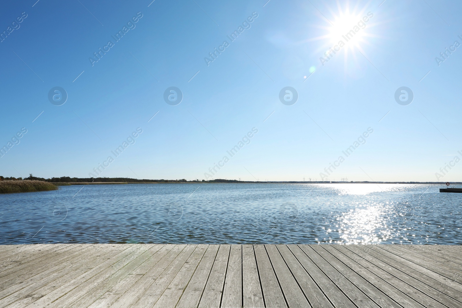 Photo of Beautiful view of wooden terrace near river on sunny day