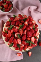 Photo of Tasty cake with fresh strawberries and mint on table, flat lay