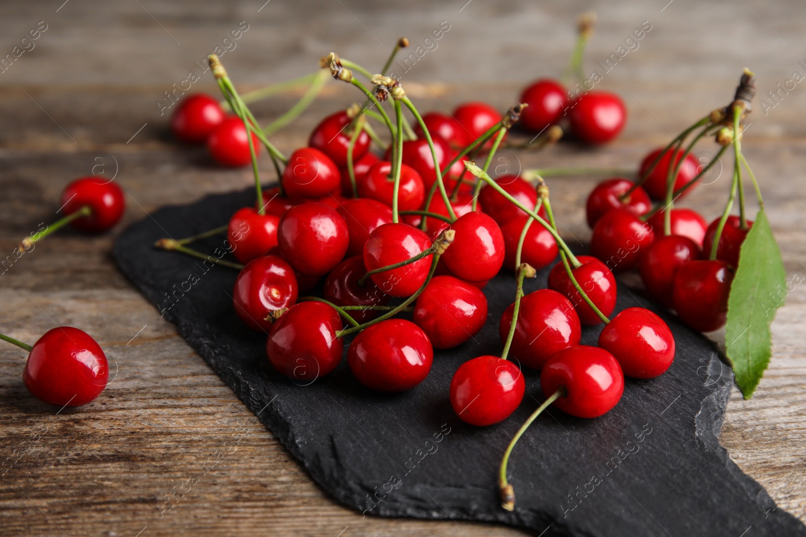 Photo of Sweet red cherries on slate plate