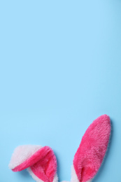 Decorative bunny ears and space for text on light blue background, flat lay. Easter holiday