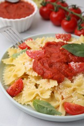 Photo of Tasty pasta with tomato sauce, cheese and basil on white table, closeup