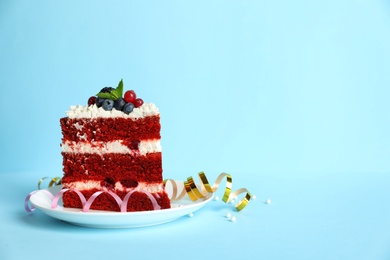 Plate with piece of delicious homemade red velvet cake and space for text on color background