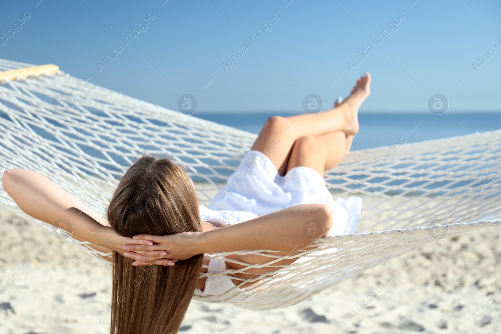 Photo of Young woman relaxing in hammock on beach