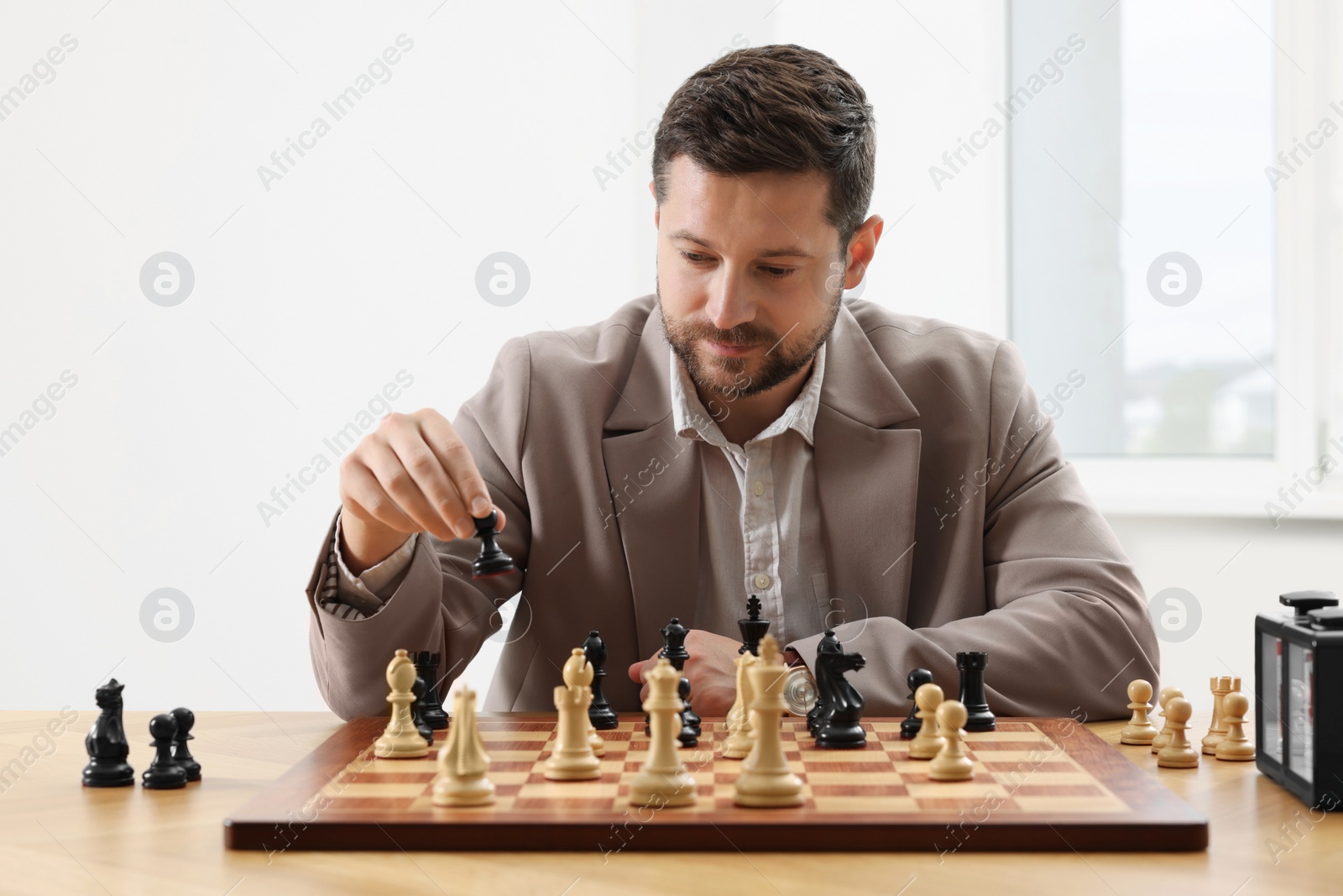 Photo of Man playing chess during tournament at table indoors