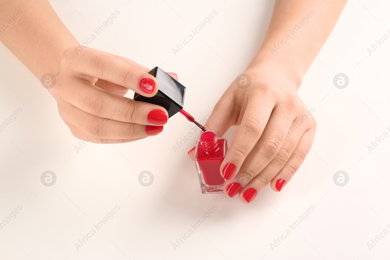 Photo of Woman applying nail polish on white background, closeup