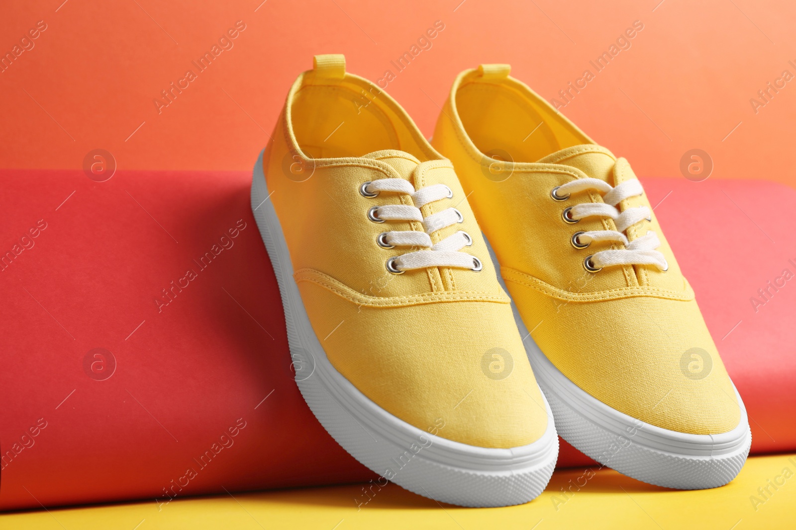 Photo of Comfortable sneakers and paper roll on color background, closeup