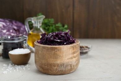 Tasty red cabbage sauerkraut and different ingredients on beige table. Space for text