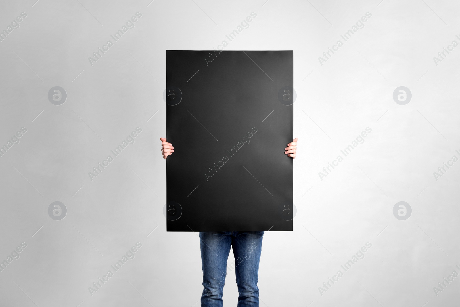 Photo of Man holding blank poster on light grey background