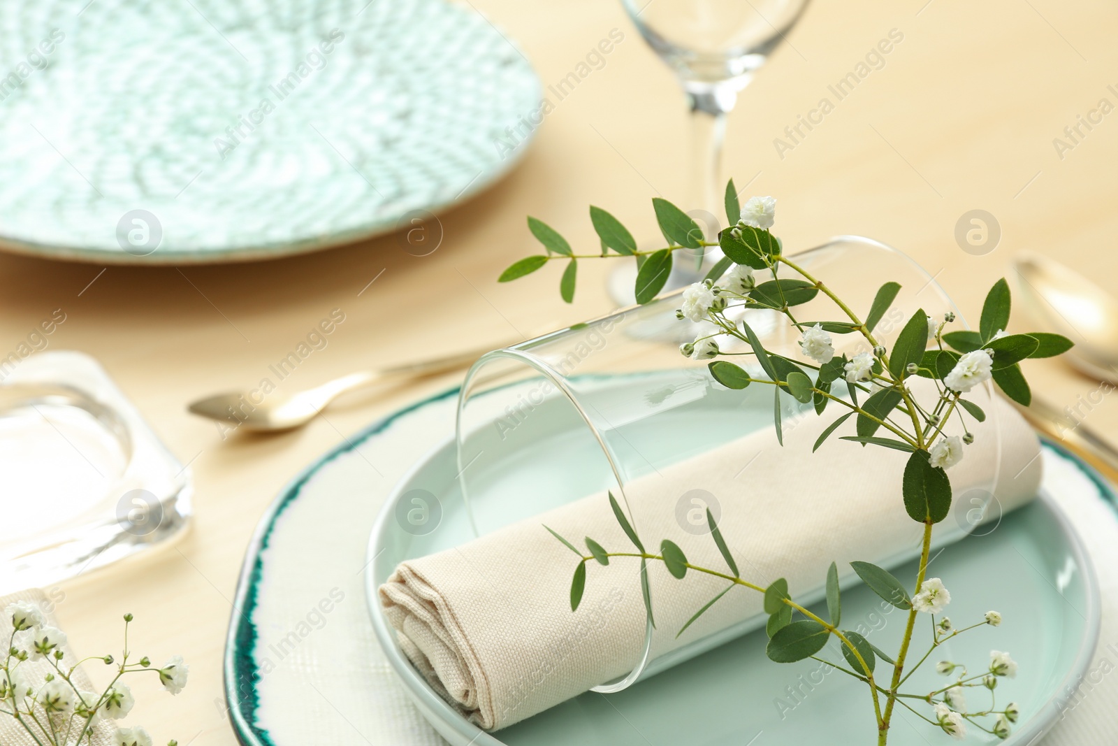 Photo of Elegant table setting with flowers and leaves, closeup