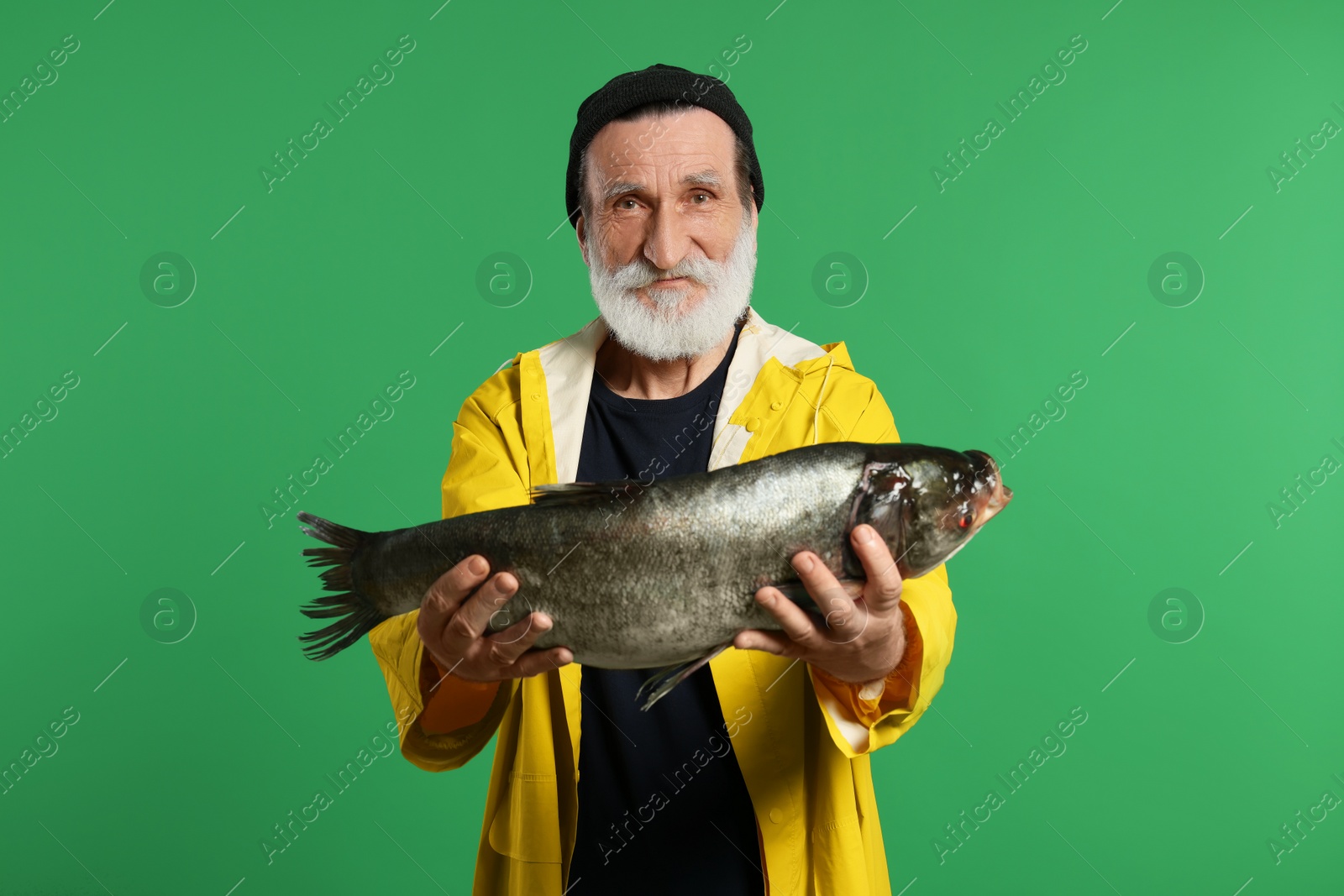 Photo of Fisherman with caught fish on green background