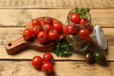 Photo of Pickling jar with fresh cherry tomatoes on wooden table