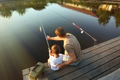 Dad and son fishing together on sunny day