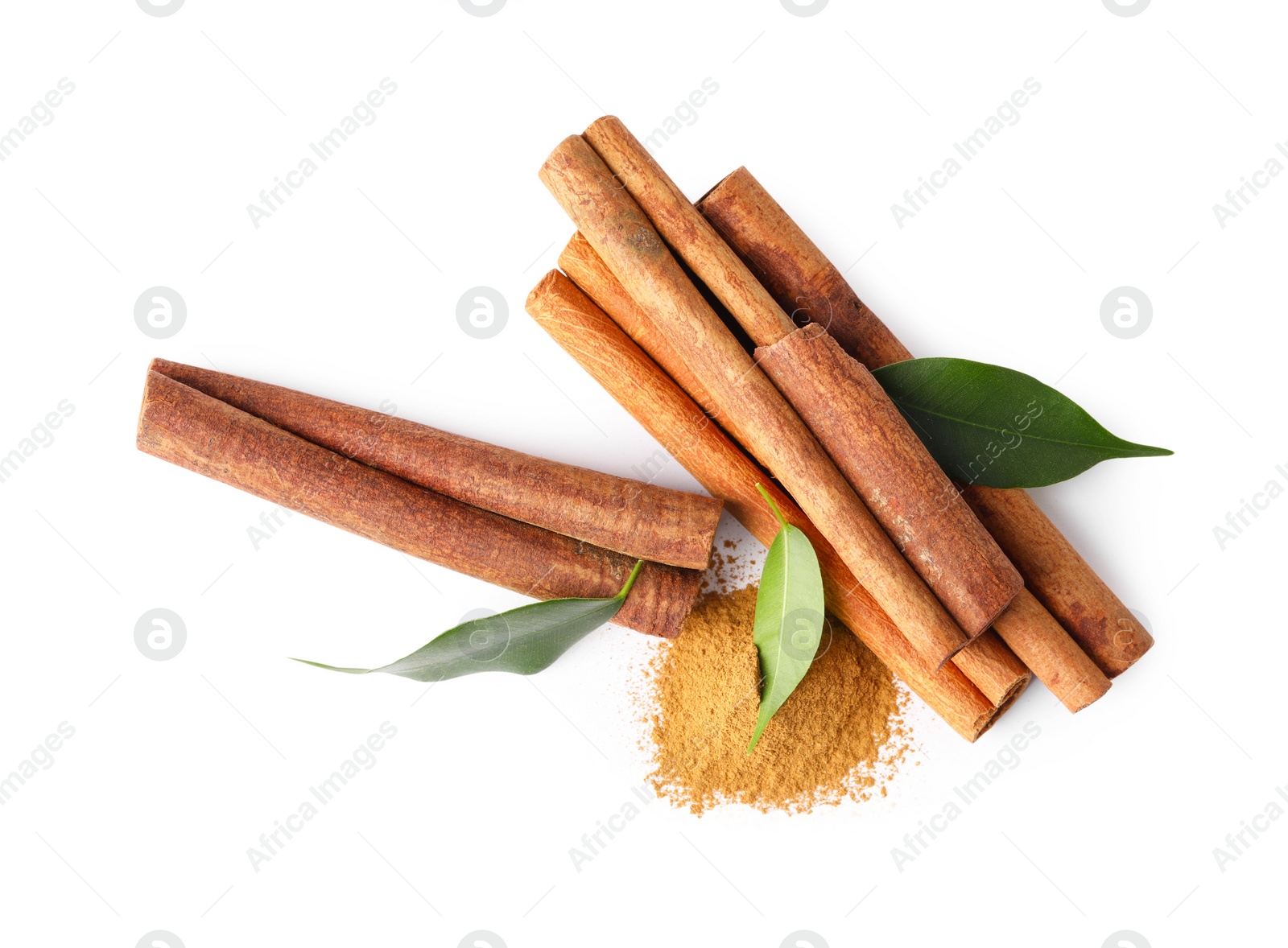 Photo of Dry aromatic cinnamon sticks, powder and green leaves isolated on white, top view